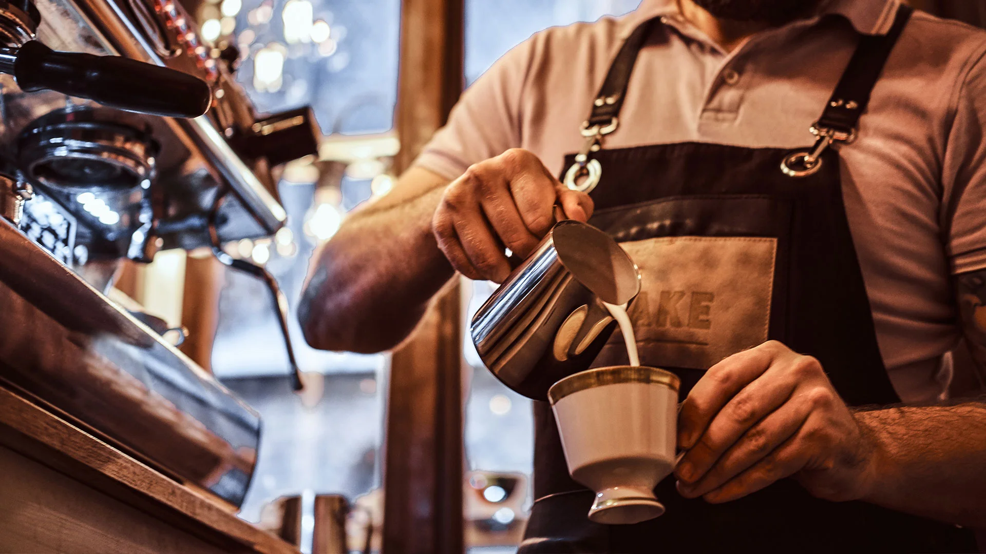 A barista steaming milk at the espresso bar